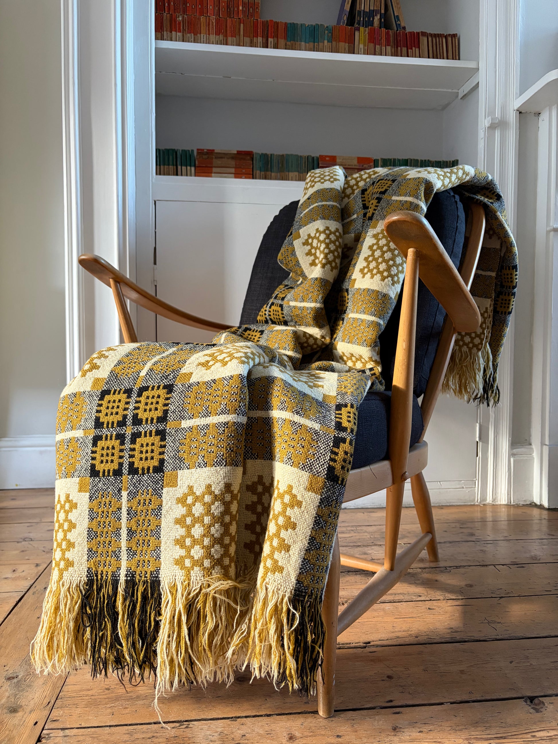 ELFYN HÊN BLANCED WLÂN LLIW MWSTARD vintage mustard wool Welsh tapestry blanket or throw Carthen over an Ercol chair