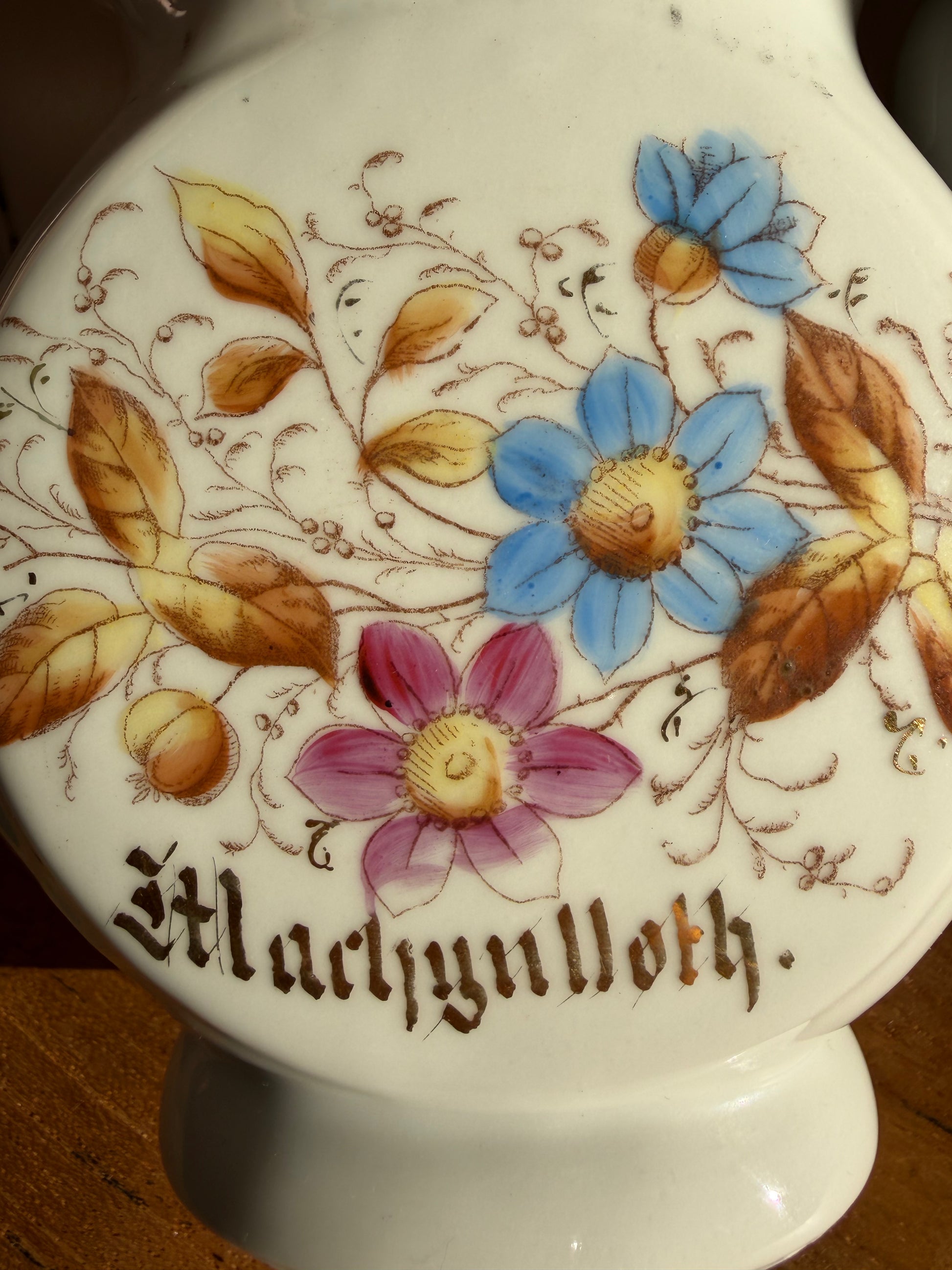 Decorative ceramic jug with floral designs and the word 'Machynlleth' in gold lettering Cymraeg Cymru