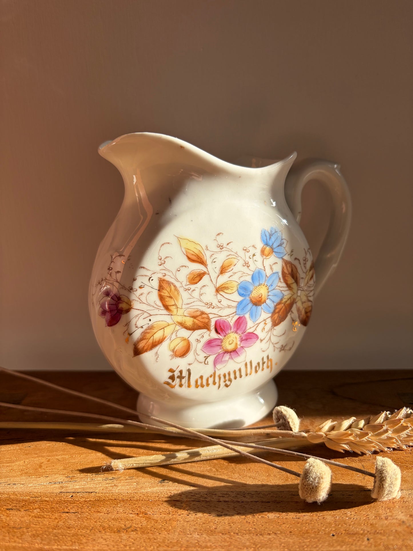 vintage welsh jug with floral design and reads MACHYNLLETH in gold lettering. Cymru Cymraeg