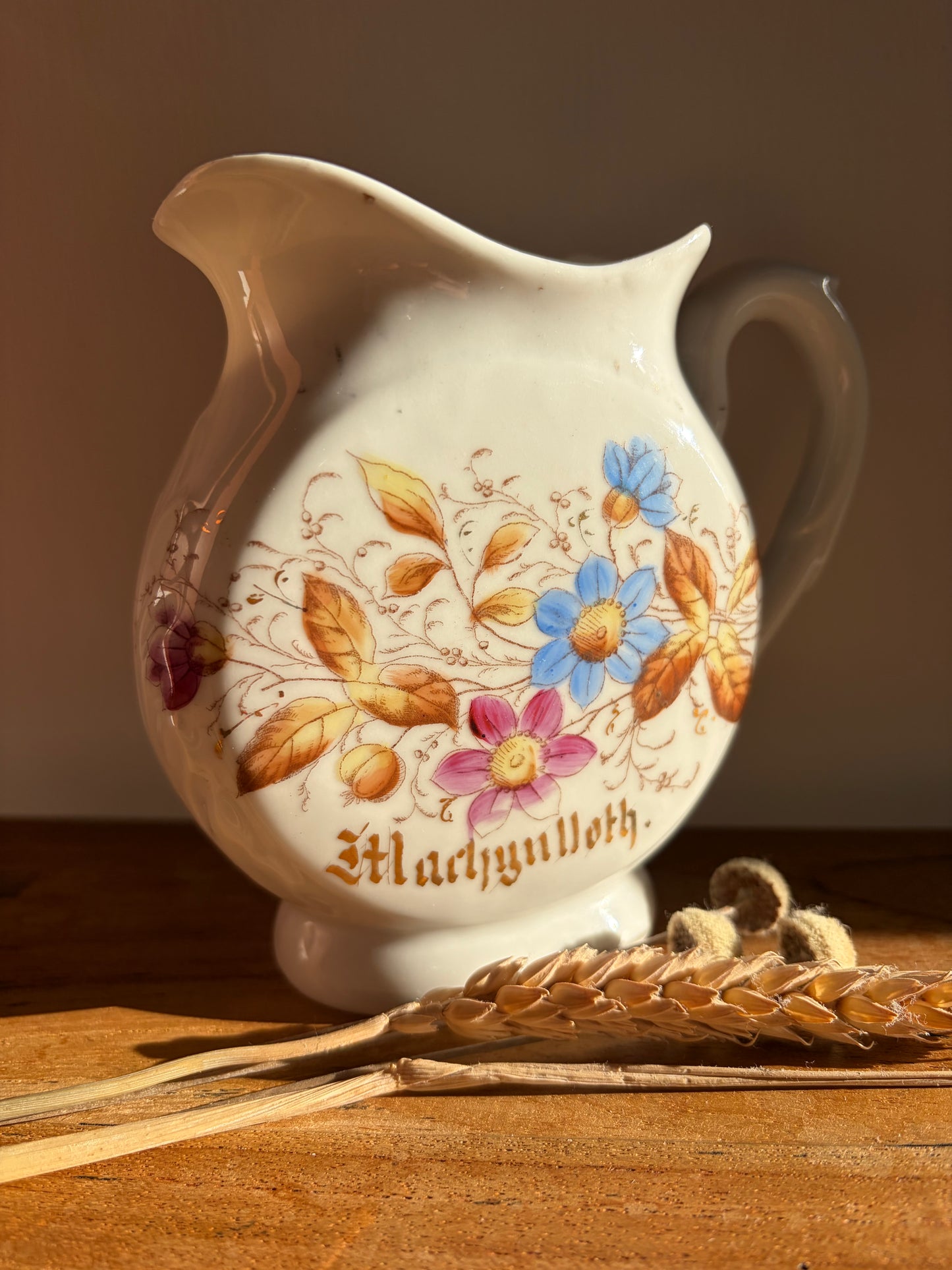 Decorative ceramic jug with floral designs and the word 'Machynlleth' in gold lettering Cymraeg Cymru